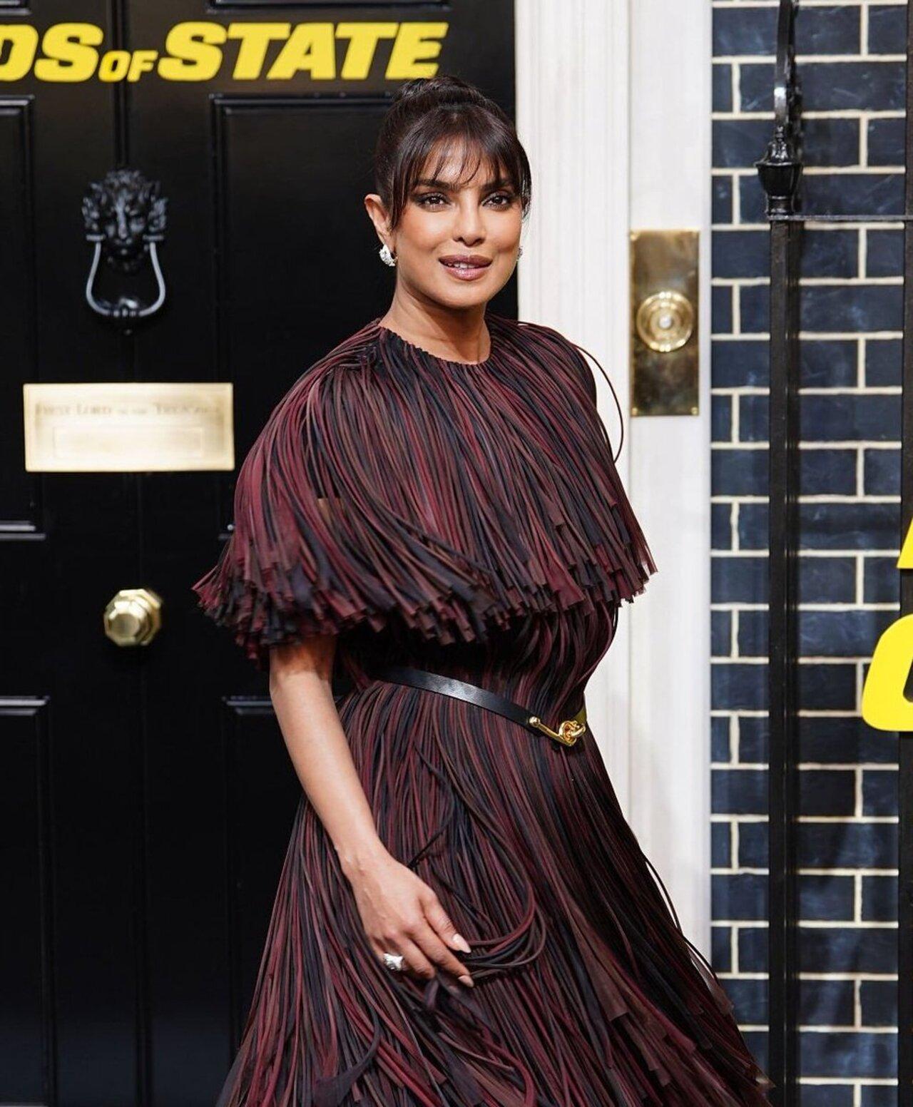 Priyanka Chopra-Jonas makes a case for high-drama elegance in a stunning burgundy and black fringed dress, cinched neatly with a slim belt to define the waist. The intricate layers of fringe create movement with every step, while classic pointed black pumps ground the look